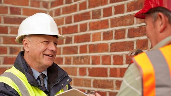 A roofer talking to a insurance agent